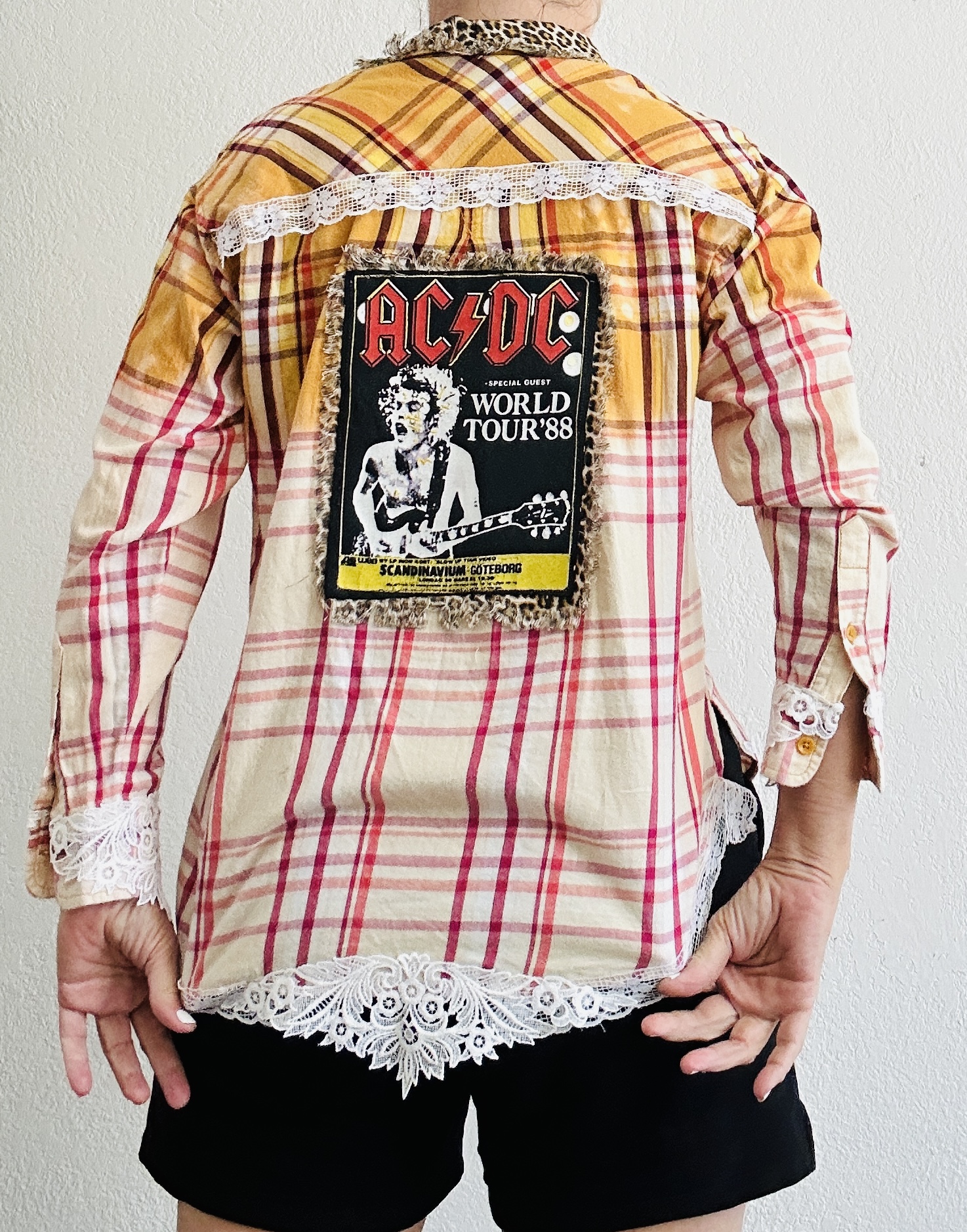 Upcycled AC/DC flannel shirt with 1988 World Tour back patch, leopard print border, hand-bleached yellow ombré, and vintage white lace trim.